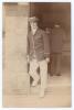 Gilbert Laird Jessop. Gloucestershire, Cambridge University & England 1894-1914. Early original sepia real photograph postcard of Jessop standing full length in a doorway wearing tour blazer and straw boater for A.C. MacLaren&rsquo;s tour to Australia 1901/02. 
