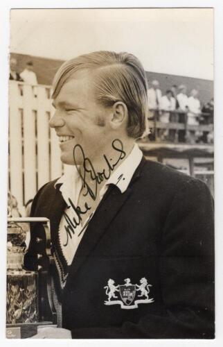 Michael John &lsquo;Mike&rsquo; Procter. Gloucestershire, Natal, Western Province, South Africa etc. 1965-1989. Mono real photograph plain back postcard of Procter, head and shoulders in profile wearing Gloucestershire blazer and holding a trophy. Nicely signed in bl