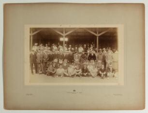 W.G. Grace early 1900s. Large early original sepia photograph of an athletics presentation ceremony taking place in front of a grandstand, dignitaries standing at a table of trophies with Grace third from the right, young athletes seated in front, and onl