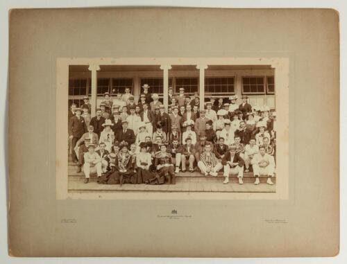 W.G. Grace at the cricket early 1900s. Large early original sepia photograph of a large group of cricketers and friends seated and standing in rows at the front of the Crystal Palace cricket pavilion in the early 1900s. Grace is depicted in the second row