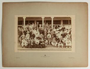 W.G. Grace at the cricket early 1900s. Large early original sepia photograph of a large group of cricketers and friends seated and standing in rows at the front of the Crystal Palace cricket pavilion in the early 1900s. Grace is depicted in the second row