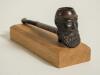 W.G. Grace smoking pipe 1895. Vulcanite cricket pipe with cricket bat shaped stem and &lsquo;Grace head&rsquo; pipe bowl with ball foot to base. Stamped &lsquo;W.G.G. ET.47. A.D. 1895&rsquo;. &lsquo;Centuplico&rsquo; and &lsquo;Made abroad&rsquo; to back of the bat. 5.5&rdquo; long. Mounted on a &lsquo;home made&rsquo; 