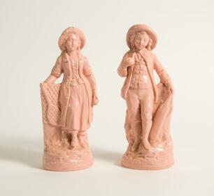 Cricket and Tennis figures. Pair of cricketing and tennis figures in terracotta glaze with originally gold lustre. The boy figure holding a cricket bat to side with ball in hand and the girl a tennis racket and ball. Both wearing hats and stood on natural