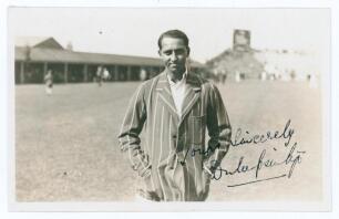 Kumar Shri Duleepsinhji. Sussex, Cambridge University & England 1924-1932. Original sepia real photograph plain back postcard of Duleep standing three quarter length at Scarborough, wearing striped blazer. Nicely signed in black ink to the photograph by D