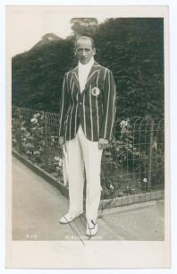 Heinrich Kleinschroth. 1930s. Sepia real photograph postcard of Kleinschroth standing full length in tennis attire and striped blazer. Very nicely signed in black ink to the photograph &lsquo;H. Kleinschroth&rsquo;. Printed title to lower edge. Publisher&rsquo;s blind embo