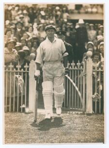 Donald George Bradman. New South Wales, South Australia & Australia 1927-1949. Wonderfully evocative original sepia press photograph of Don Bradman having just passed thorough the gate onto the pitch at Melbourne to bat against England in the second Test 