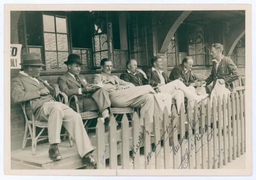 Australia tour to South Africa 1935/36. Excellent original mono press photograph of seven players seated at the pavilion at Old Wanderers, Johannesburg, three Australians in tour blazer, one South Africa in blazer, and three others in formal attire. Signe