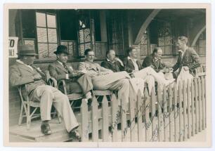 Australia tour to South Africa 1935/36. Excellent original mono press photograph of seven players seated at the pavilion at Old Wanderers, Johannesburg, three Australians in tour blazer, one South Africa in blazer, and three others in formal attire. Signe
