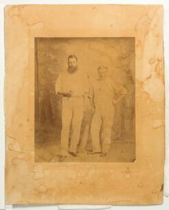 William Gilbert Grace. Gloucestershire & England. 1865-1908 and Henry &lsquo;Harry&rsquo; Jupp, Surrey & England 1862-1881. Original sepia photograph of the two players full length stood side by side, Grace holding a cricket ball and Jupp a cricket bat, both wearing 