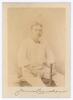 James Cranston. Gloucestershire 1976-1899. Excellent mono studio photograph of Cranston, sat wearing cricket attire with bat to side, the photograph laid down to card. Nicely signed in ink to lower border of the card by Cranston. 5&rdquo;x7&rdquo;. Some slight fading