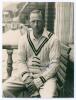 Robert Walter Vivian Robins. Cambridge University, Middlesex & England 1926-1951. Original mono photograph of Robins, three quarter length in cricket attire sat in front of a pavilion, probably Lord&rsquo;s. Signed by Robins to photograph. The photograph measur