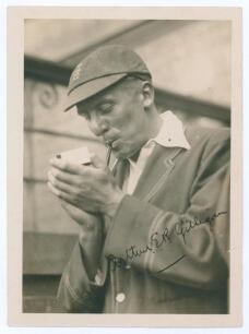 Arthur Edward Robert Gilligan. Cambridge University, Surrey, Sussex & England 1919-1932. Mono photograph of Gilligan, half length, wearing M.C.C. blazer and England cap lighting up his pipe. Signed in ink to the photograph by Gilligan. The photograph meas