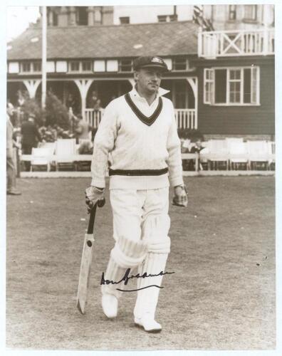Don Bradman. A nice high quality sepia tone copy photograph of Bradman walking out to bat with the pavilion and deckchairs in the background. Ground and tour not known. Nicely signed in bold ink by Bradman in later years. 10&rdquo;x8&rdquo;. Very good condition.