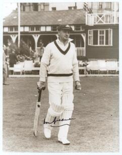 Don Bradman. A nice high quality sepia tone copy photograph of Bradman walking out to bat with the pavilion and deckchairs in the background. Ground and tour not known. Nicely signed in bold ink by Bradman in later years. 10&rdquo;x8&rdquo;. Very good condition.