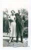 Don Bradman. Small original candid mono photograph of Bradman standing full length in formal attire, his arm around the shoulder of his wife, Jessie. Signed in blue ink to the photograph by both Don and Jessie Bradman. Annotation in ink to verso, &lsquo;July 19